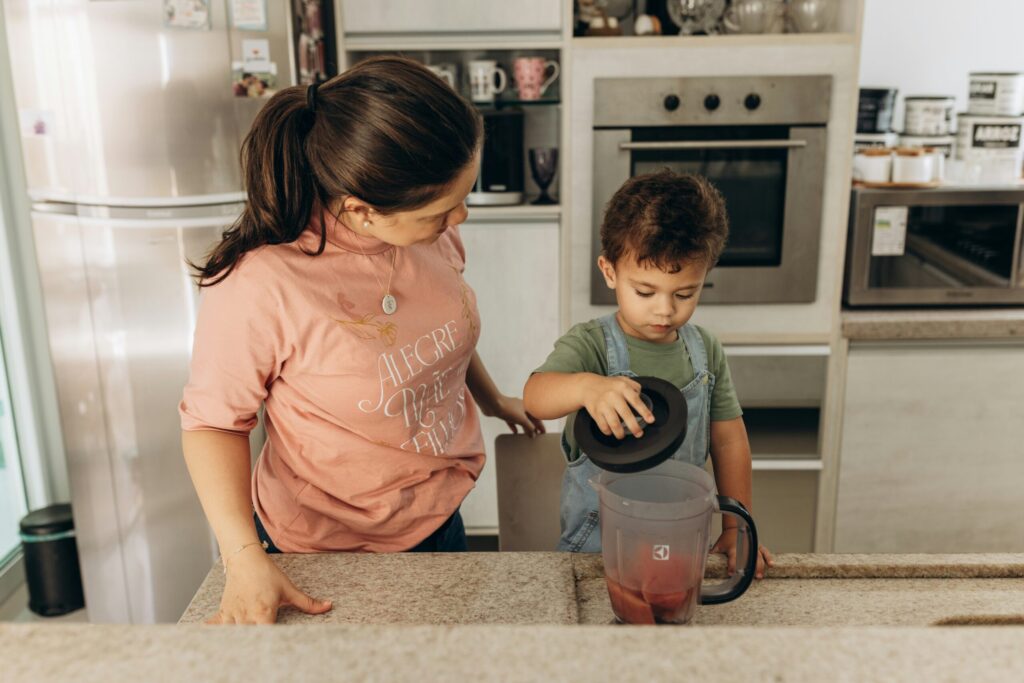 踏み台に乗ってお手伝いをする子どもとママの様子