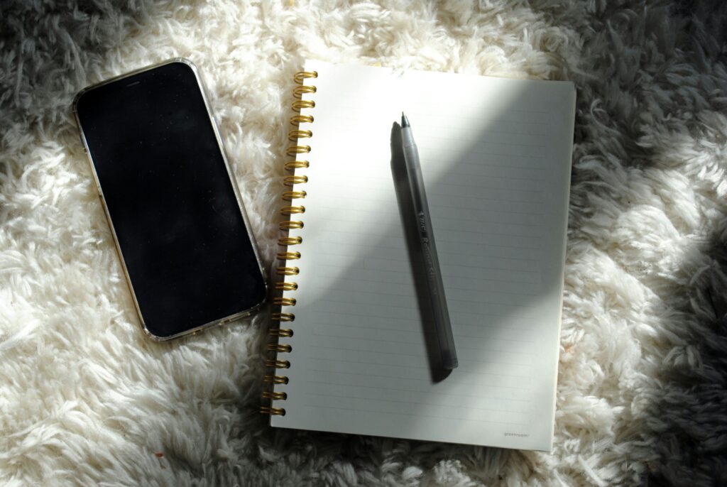 スマホにメモしたことを見て連絡帳を書こうとするイメージ画像