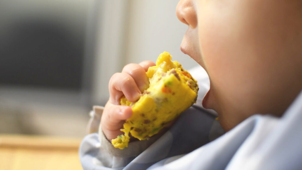 菓子パンを食べようとしているこども