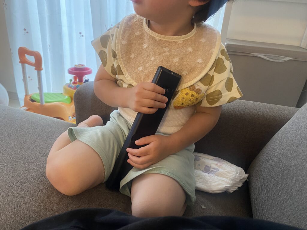 テレビのリモコンを大事そうに持っている2歳長男